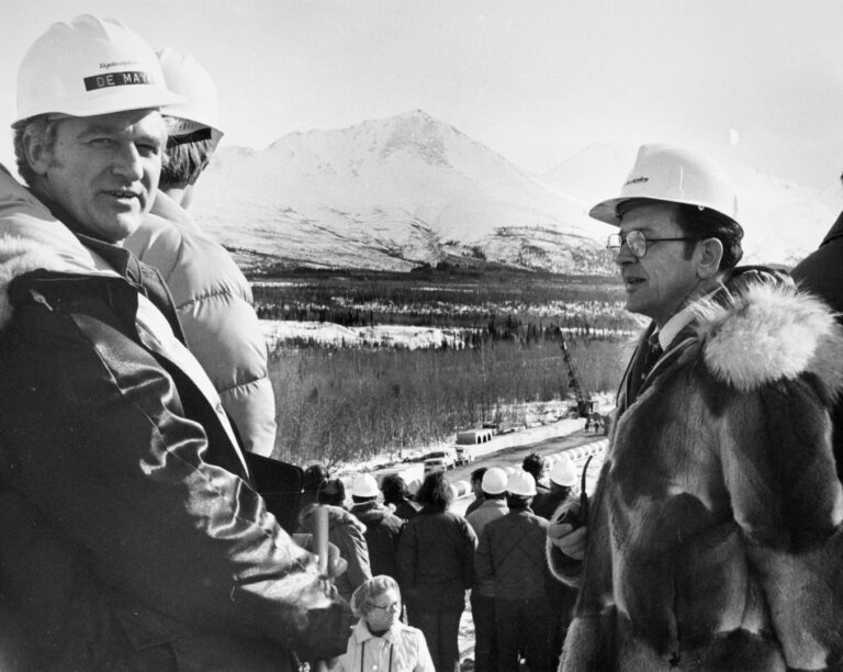 Alyeska Pipeline Company Vice President Peter DeMay and Sen. Ted Stevens watch as the first section of the Trans Alaska Pipeline is laid at Tonsina River in March 1975. Stevens Foundation photo. Archival quality TIFF exists.