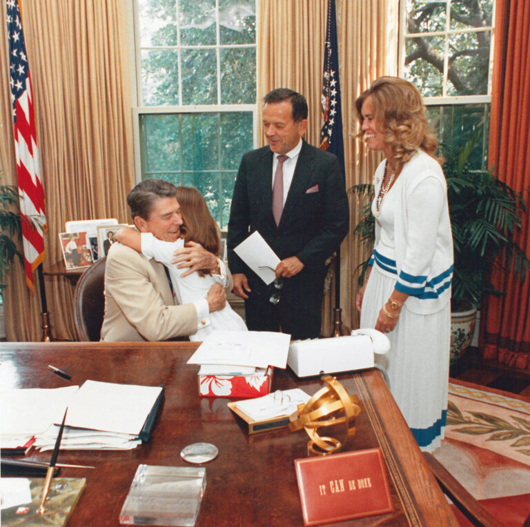 Lily Stevens, 7, gives President Ronald Reagan a goodbye hug after the Stevens family made a visit to the President in his office on July 26, 1988. White House/Stevens Foundation photo