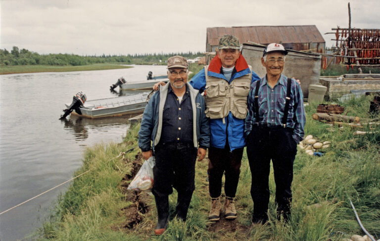 Senator Ted Stevens visits with Mike Andrew, left, and John Tallekpalek, right, at John and his wife Mary's fish camp on the Branch River in July, 1993. Sen. Stevens loved to fish and stopped to say hello when he was in the area. John and Mary Tallekpalek, from Levelock up river, lived a traditional subsistence lifestyle and welcomed the Senator and many visitors over the years. Stevens Foundation Photo