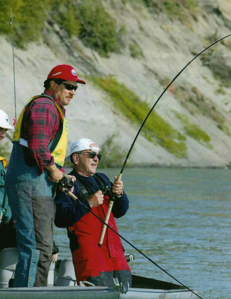 Senator Ted Stevens hooks a large salmon during the Kenai River Classic on July 3, 2002 as guide Mike Fenton reels in his line. KRSA / Fitzgerald photography