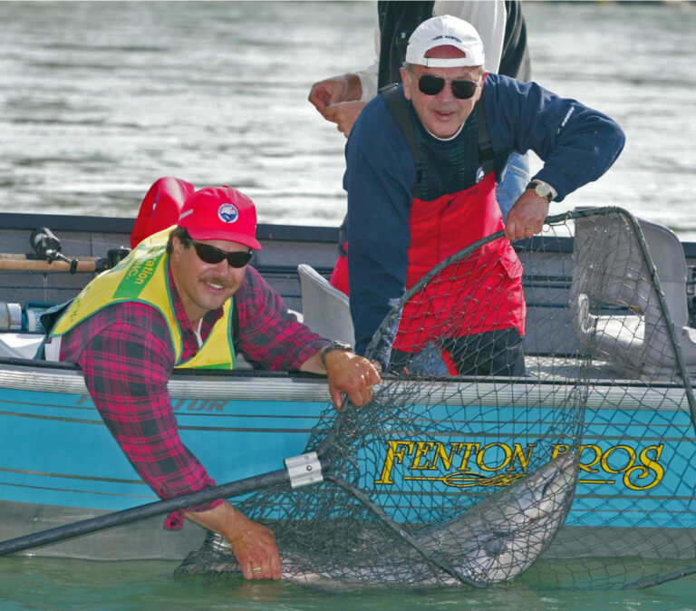 Senator Ted Stevens and Mike Fenton with a salmon that the Senator caught during the Kenai River Classic in July of 2002. Photo courtesy Kenai River Sportfishing Association/Fitzgerald Photgraphy.